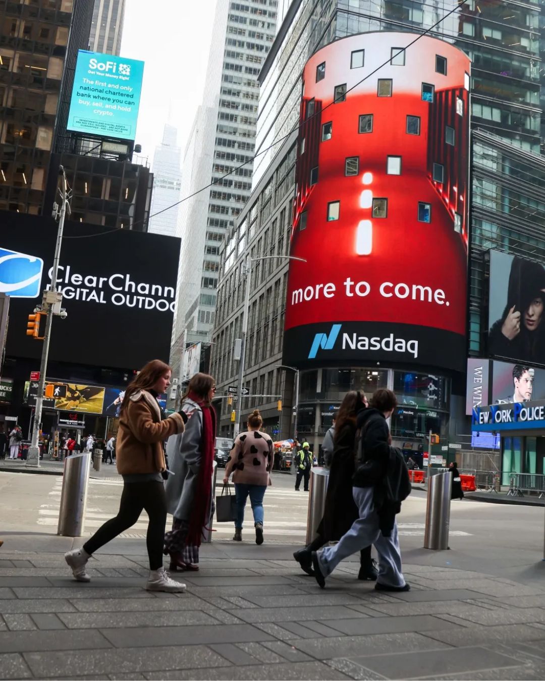 Nasdaq billboard in Times Square displaying 'more to come' in white on red background